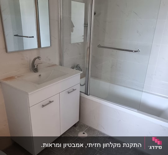 אמבטיון זכוכית מותקן על אמבטיה בחדר רחצה מעוצב